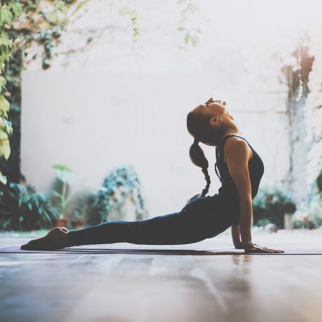 Portrait of young woman practicing yoga indoor.